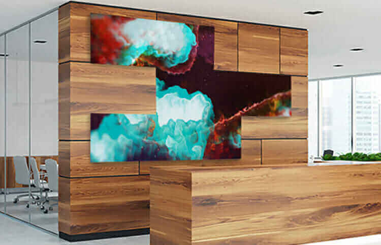 Modern office lobby featuring vibrant video walls with abstract digital art display, wood panel decor, and conference room.