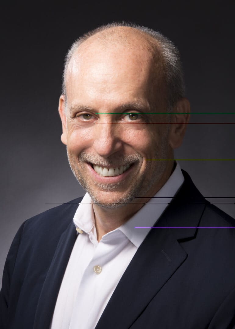 Smiling executive in a navy blazer and white open-collar shirt